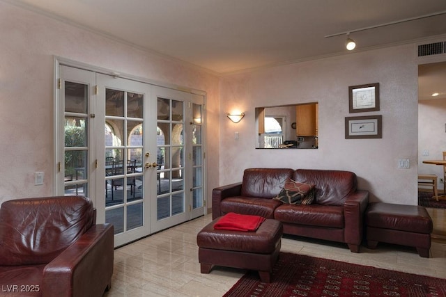 living area with french doors, visible vents, and crown molding