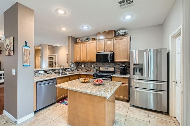 kitchen with visible vents, decorative backsplash, light stone countertops, stainless steel appliances, and a sink