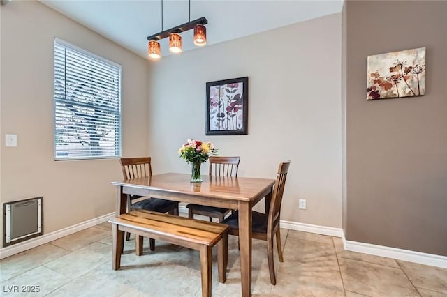 dining space featuring baseboards and light tile patterned flooring