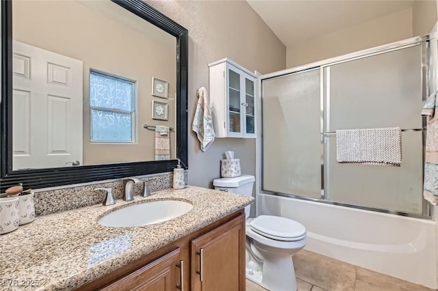 full bathroom featuring shower / bath combination with glass door, vanity, toilet, and tile patterned floors