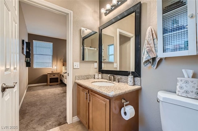 bathroom with baseboards, connected bathroom, vanity, and toilet