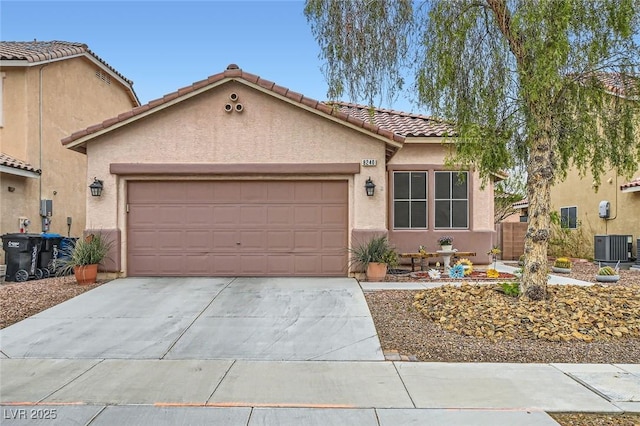 view of front of house with a garage, concrete driveway, central AC, and stucco siding