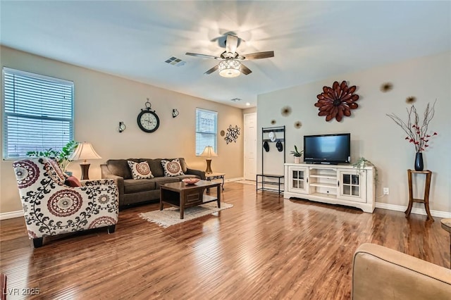 living room with a ceiling fan, baseboards, visible vents, and wood finished floors