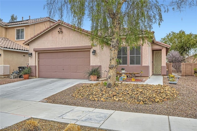 view of front of house with a garage, concrete driveway, a gate, and stucco siding