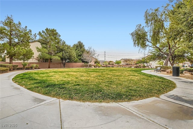 view of property's community featuring fence and a lawn