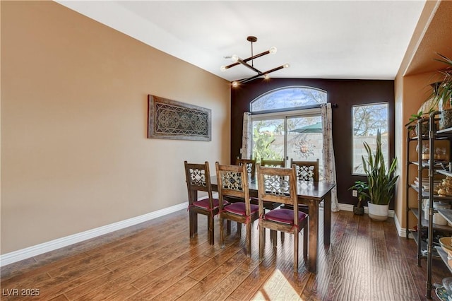 dining area featuring baseboards, a chandelier, and wood finished floors