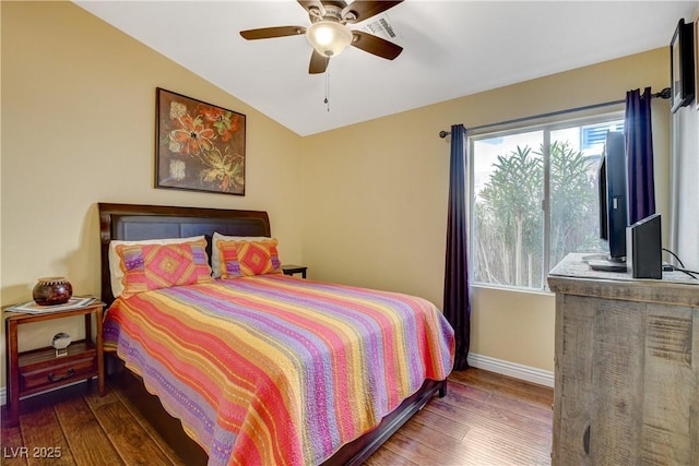 bedroom with vaulted ceiling, wood-type flooring, visible vents, and baseboards