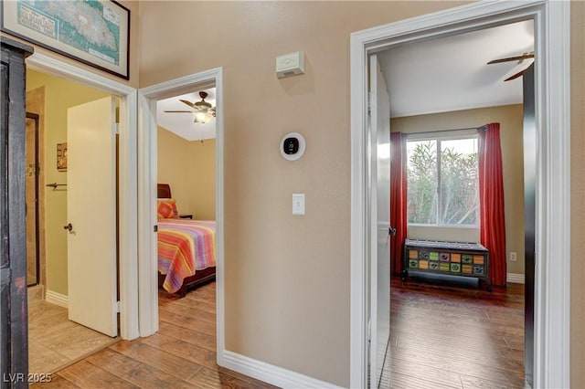 hallway with baseboards and wood finished floors