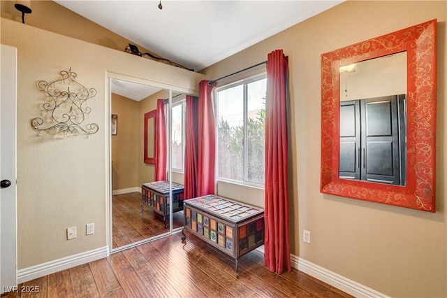 interior space with lofted ceiling, hardwood / wood-style floors, and baseboards