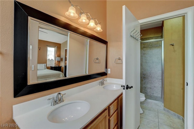 ensuite bathroom featuring a stall shower, tile patterned flooring, a sink, and toilet