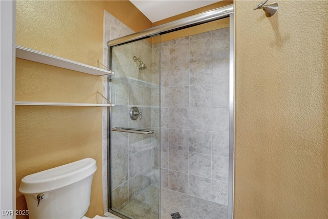 full bathroom with toilet, a stall shower, and a textured wall