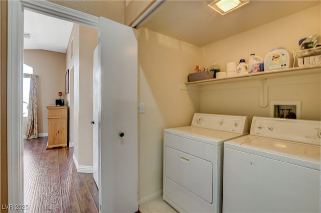 washroom featuring laundry area, washing machine and dryer, dark wood finished floors, and baseboards