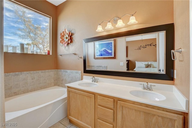 ensuite bathroom featuring double vanity, a garden tub, tile patterned flooring, and a sink