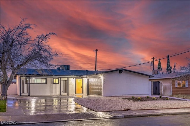 mid-century inspired home featuring driveway and stucco siding