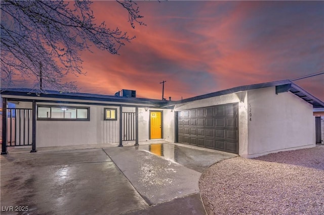 mid-century home featuring a garage and stucco siding