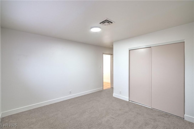 unfurnished bedroom featuring a closet, carpet flooring, visible vents, and baseboards