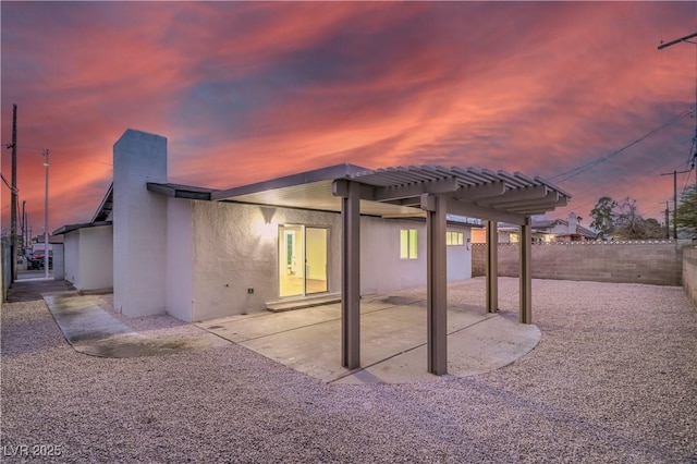 rear view of property featuring a patio area, a fenced backyard, a pergola, and stucco siding