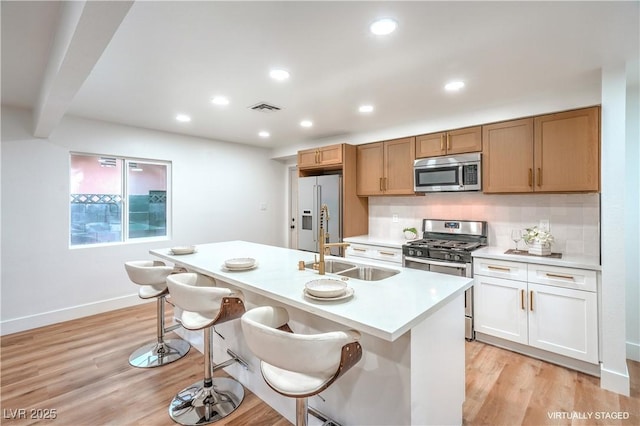 kitchen featuring appliances with stainless steel finishes, light countertops, visible vents, and light wood-style flooring