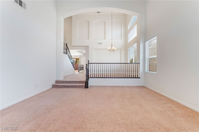 interior space with baseboards, carpet flooring, visible vents, and a notable chandelier