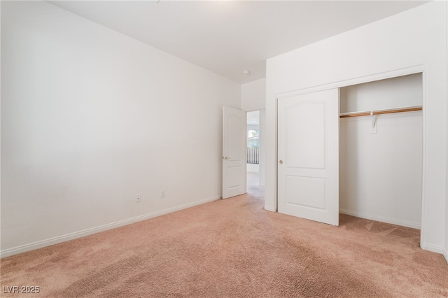 unfurnished bedroom with baseboards, a closet, and light colored carpet