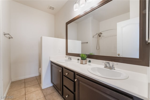 bathroom with double vanity, tile patterned flooring, a sink, and toilet