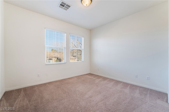 spare room featuring visible vents, light carpet, and baseboards