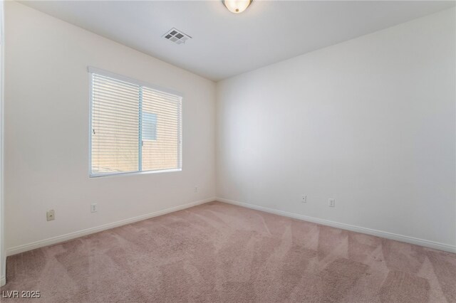 unfurnished room with visible vents, light carpet, and baseboards