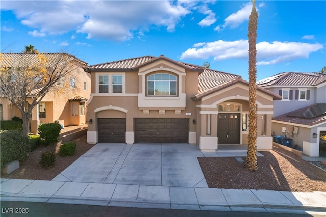 mediterranean / spanish home featuring driveway, an attached garage, a tile roof, and stucco siding