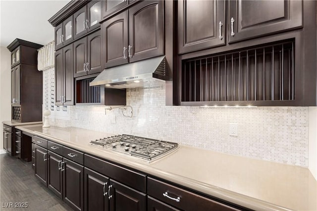 kitchen featuring light countertops, dark brown cabinetry, and under cabinet range hood