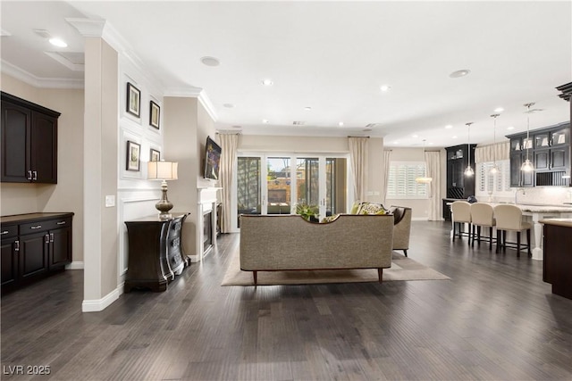 living room with crown molding, dark wood finished floors, and a wealth of natural light