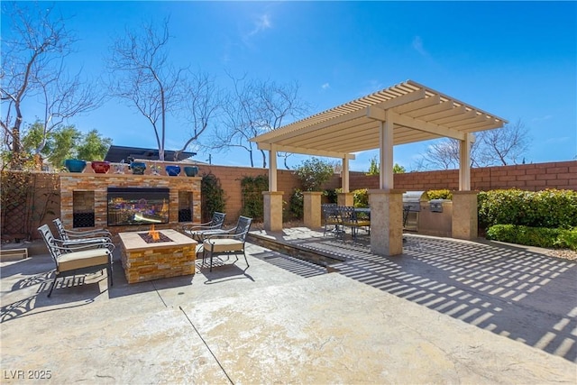 view of patio / terrace with a fire pit, exterior kitchen, fence, and a pergola