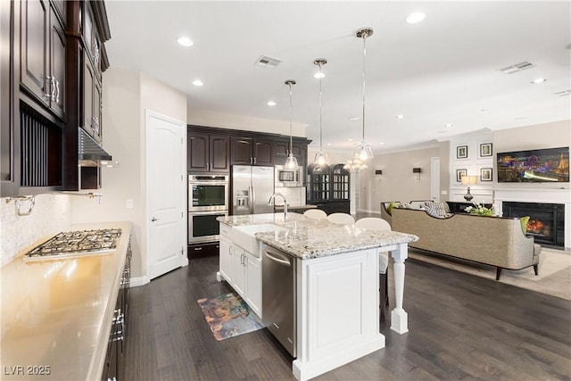 kitchen featuring appliances with stainless steel finishes, visible vents, a sink, and dark brown cabinetry