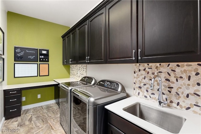 laundry area with independent washer and dryer, a sink, cabinet space, and baseboards