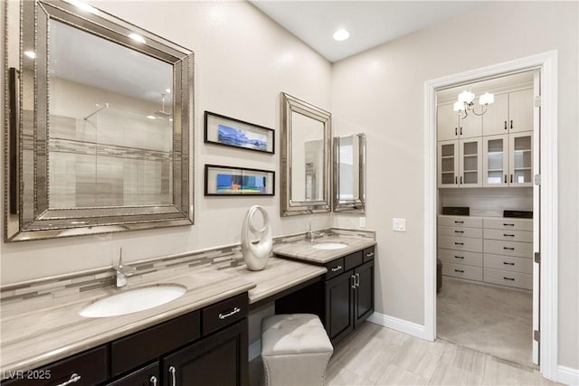 full bath featuring a tile shower, vanity, and baseboards