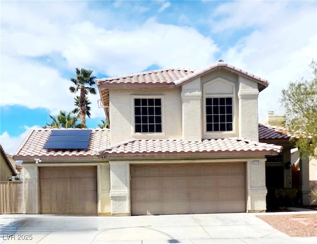 mediterranean / spanish home featuring driveway, a tile roof, solar panels, and stucco siding