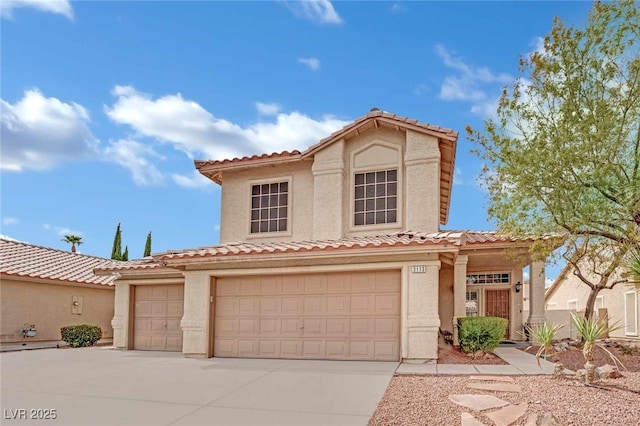 mediterranean / spanish-style home featuring concrete driveway, a tiled roof, a garage, and stucco siding