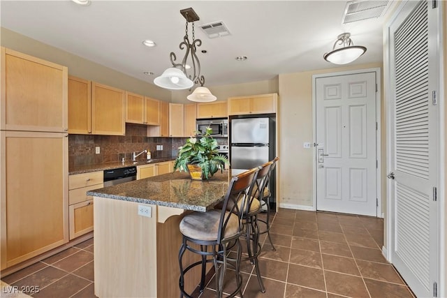 kitchen with stainless steel appliances, dark tile patterned flooring, visible vents, backsplash, and light brown cabinetry