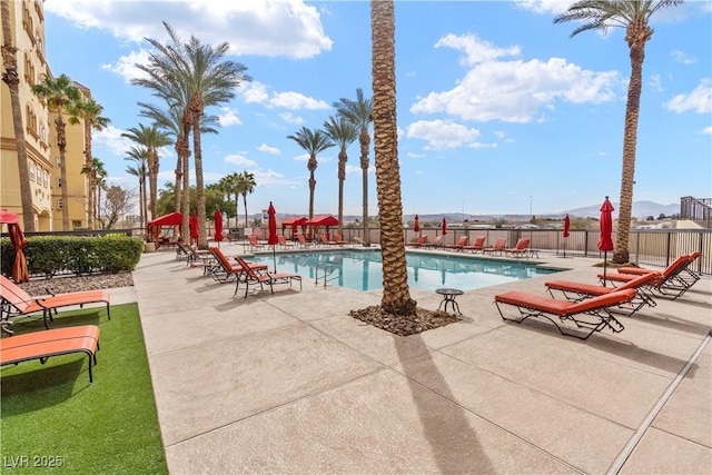 community pool with a patio and fence