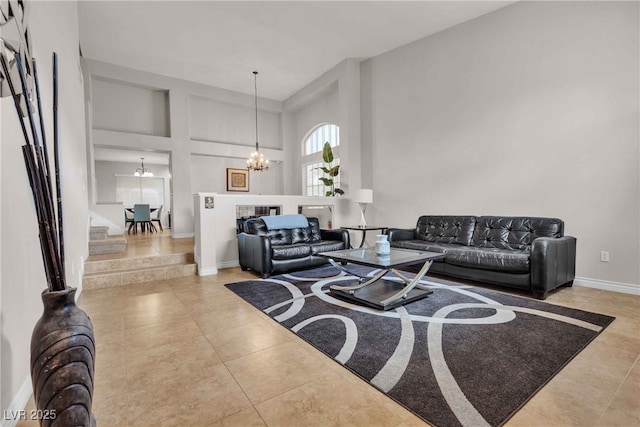 living area featuring a chandelier, tile patterned flooring, a towering ceiling, baseboards, and stairway