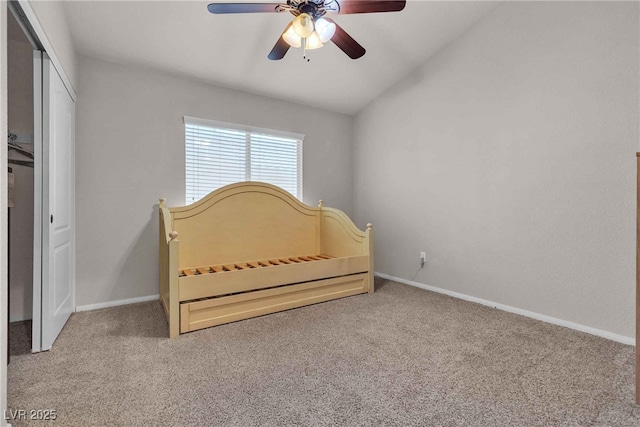 carpeted bedroom featuring a ceiling fan, a closet, vaulted ceiling, and baseboards