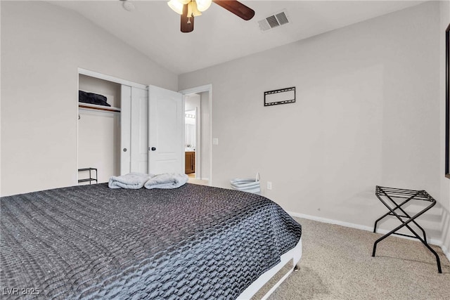 bedroom with a closet, visible vents, carpet flooring, vaulted ceiling, and baseboards