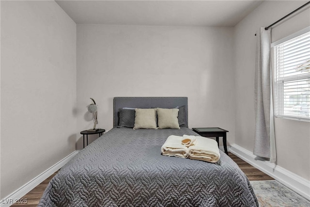 bedroom featuring baseboards and wood finished floors