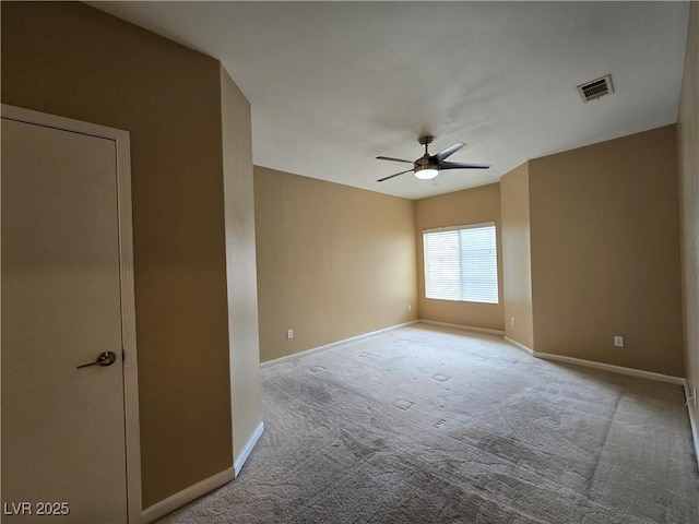 spare room featuring ceiling fan, carpet floors, visible vents, and baseboards