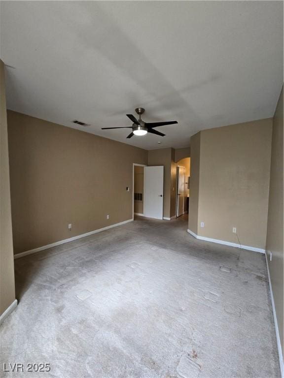 empty room featuring arched walkways, carpet, visible vents, ceiling fan, and baseboards