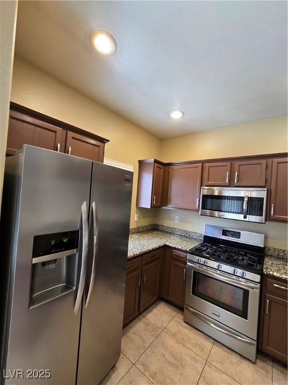 kitchen with appliances with stainless steel finishes and dark brown cabinets