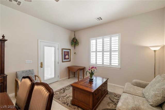 living room with light carpet, visible vents, and baseboards