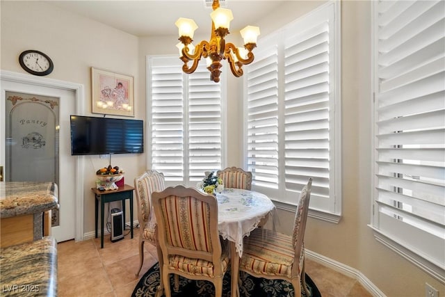 dining space with light tile patterned floors, baseboards, and an inviting chandelier