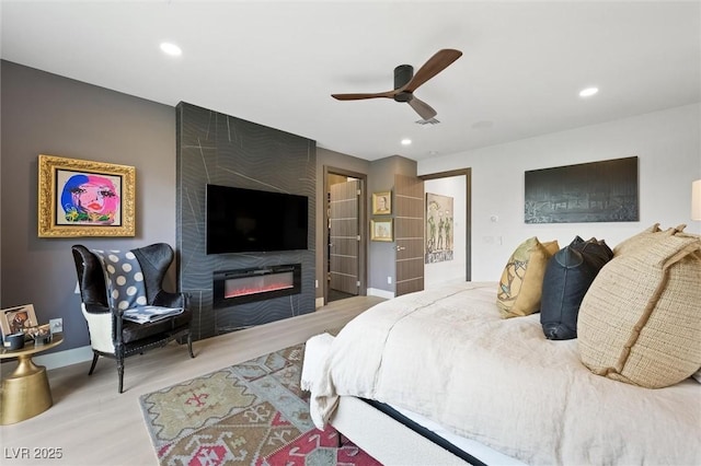 bedroom with baseboards, a fireplace, wood finished floors, and recessed lighting