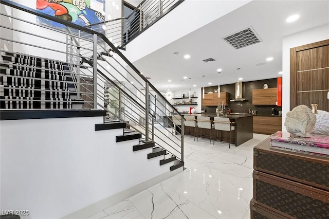 stairs with recessed lighting, marble finish floor, visible vents, and baseboards