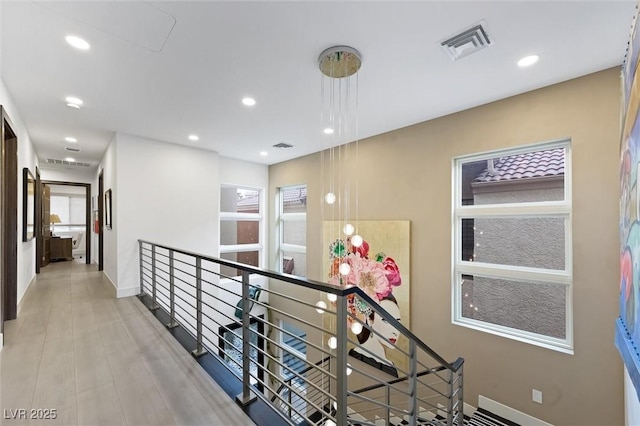 hall featuring baseboards, an upstairs landing, visible vents, and recessed lighting